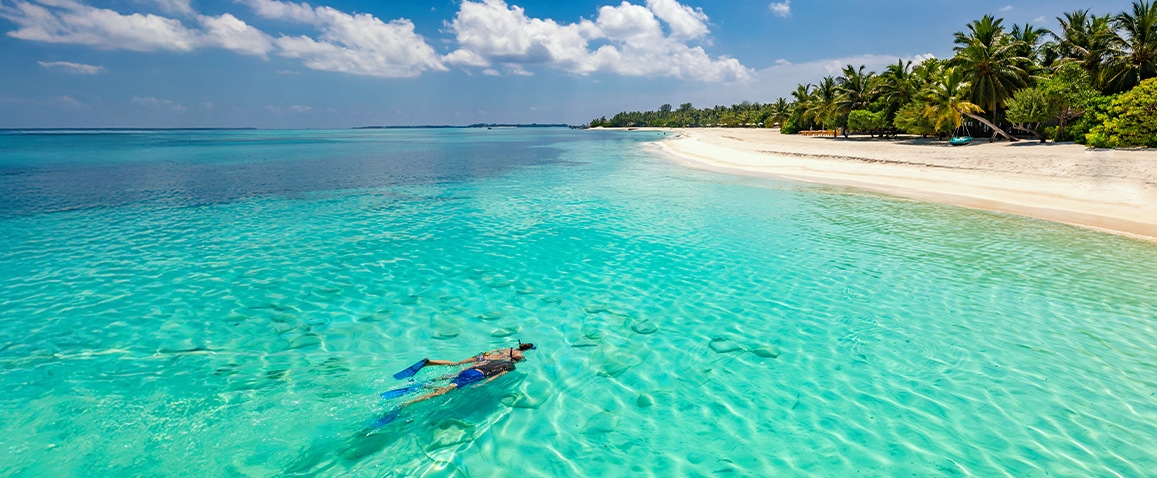nurek w błekitnych wodach ocenu, piękna biała plaża, rybki w wodzie, Malediwy